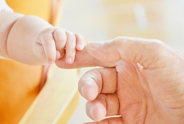 Baby's hand holding finger